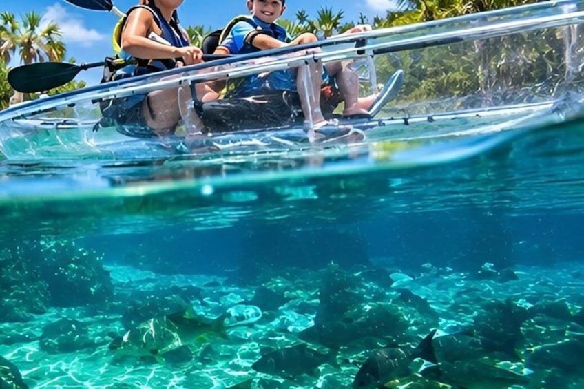 A clear water kayak with two people paddling, surrounded by tropical scenery. 1