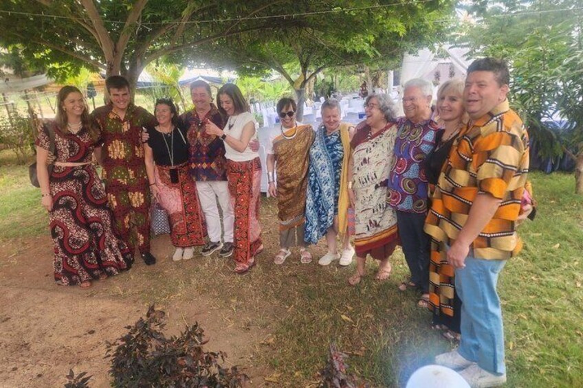 A group of people standing outdoors under a tree. 2