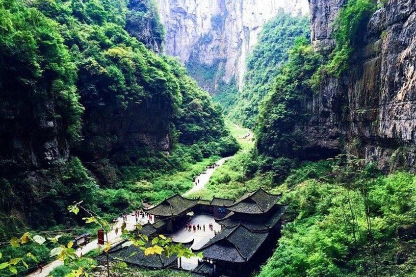 A traditional building nestled in a lush valley with steep cliffs. 3