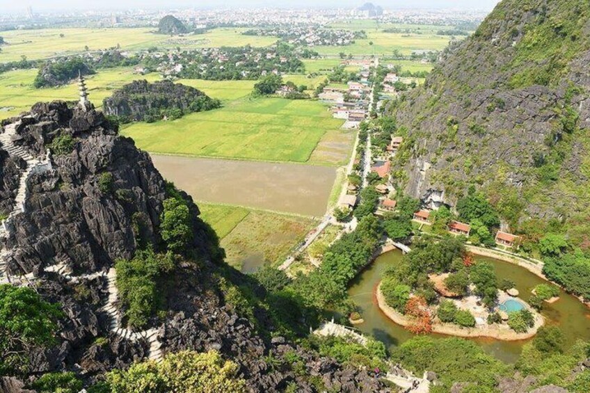 A mountainous landscape with a temple on a cliff, a river, and a village below. 5