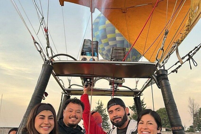 Un globo aerostático con un estampado a cuadros, una persona con una chaqueta roja y otra con una chaqueta blanca. 4