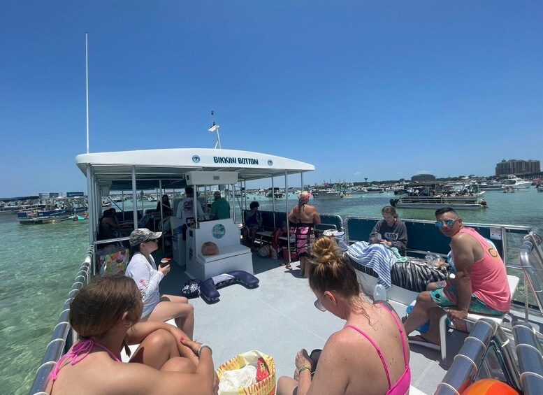 A boat with people sunbathing and a marina in the background. 5