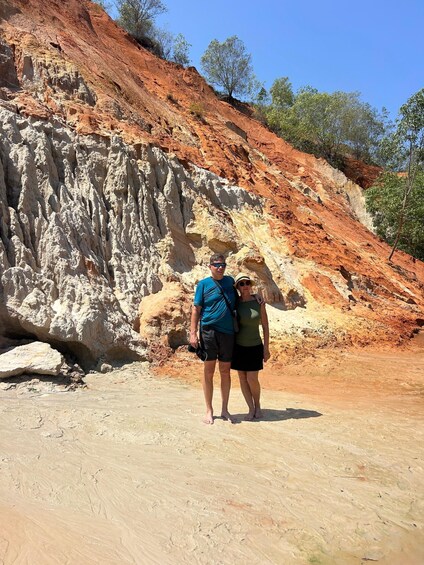 A rocky terrain with a man and a woman standing in the foreground. 5
