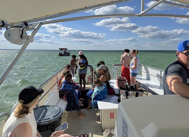 A boat with people on deck, a clear sky, and calm water. 4