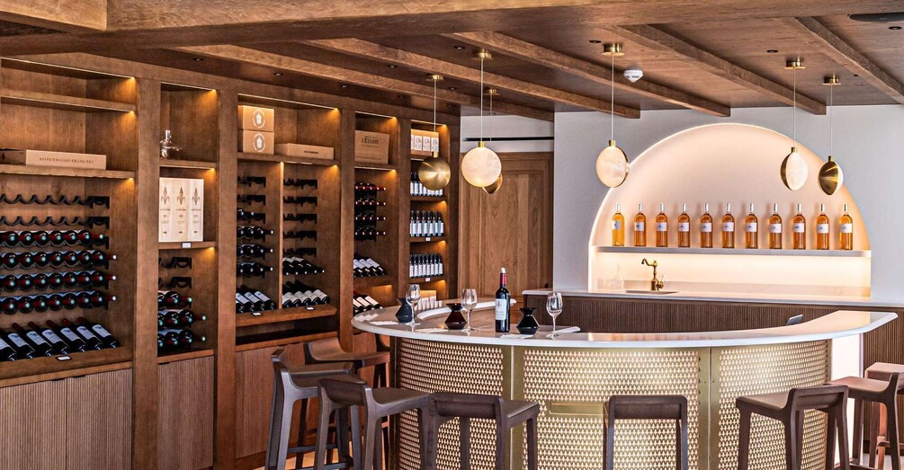 A wine bar with wooden shelves, hanging lights, and a counter with bottles. 3