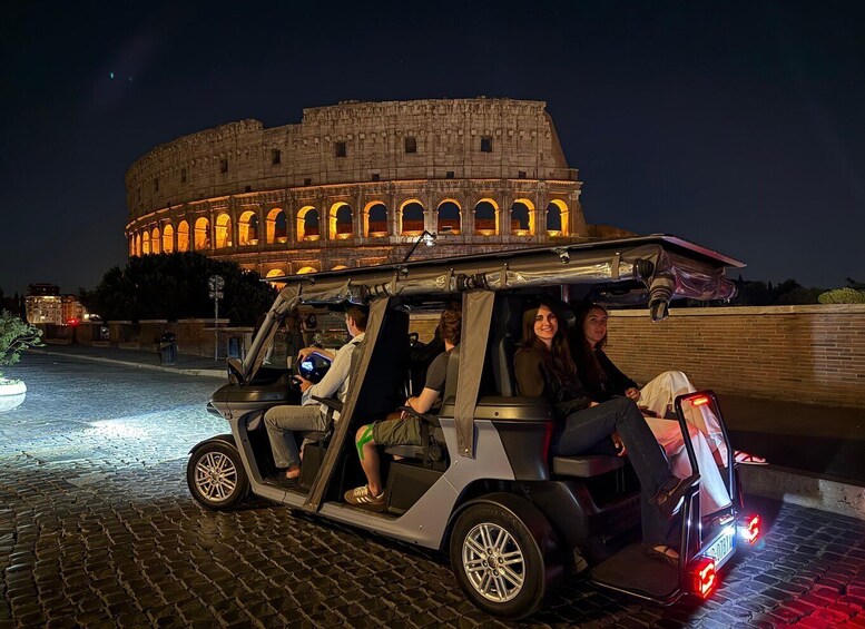 A group of people in a golf cart with a historic building in the background. 3