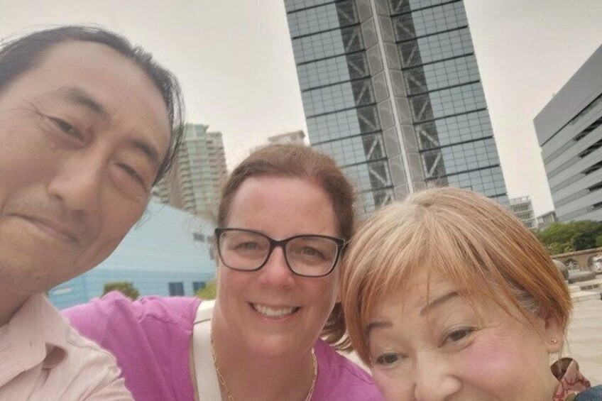 Three people in front of modern buildings with glass facades. 3