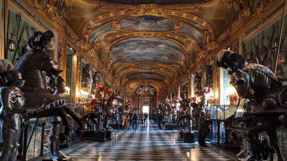 An ornate hallway with sculptures and a checkered floor. 3