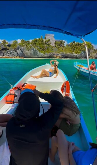 A boat with two people, one wearing a life jacket, and another person in the background. 3