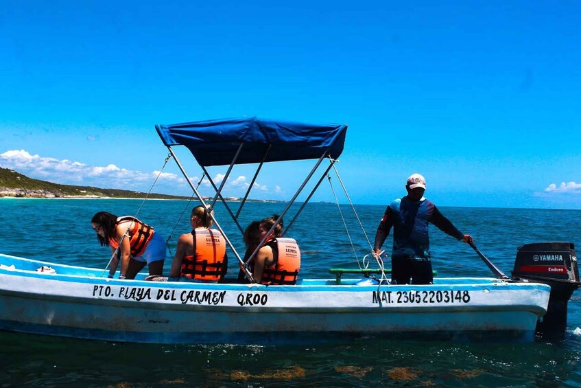 A boat with people wearing life jackets, a blue canopy, and a Yamaha outboard motor. 2