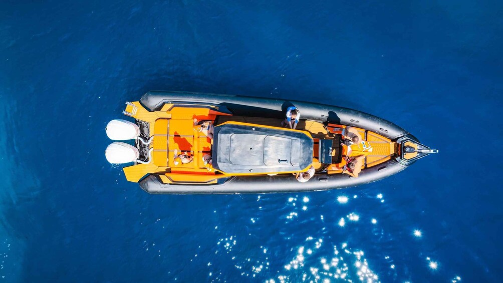 A small inflatable boat with a central seating area and two outboard motors. 5