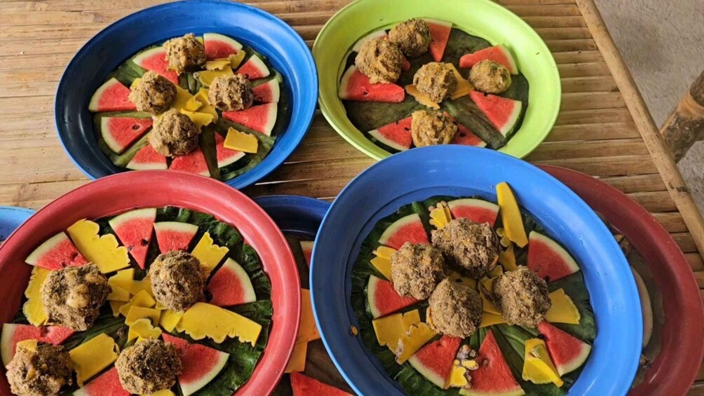 Four bowls with meatballs, watermelon slices, and cheese on a wooden surface. 3