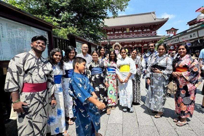A group of people in traditional Japanese attire standing in front of a temple with a pagoda. 5