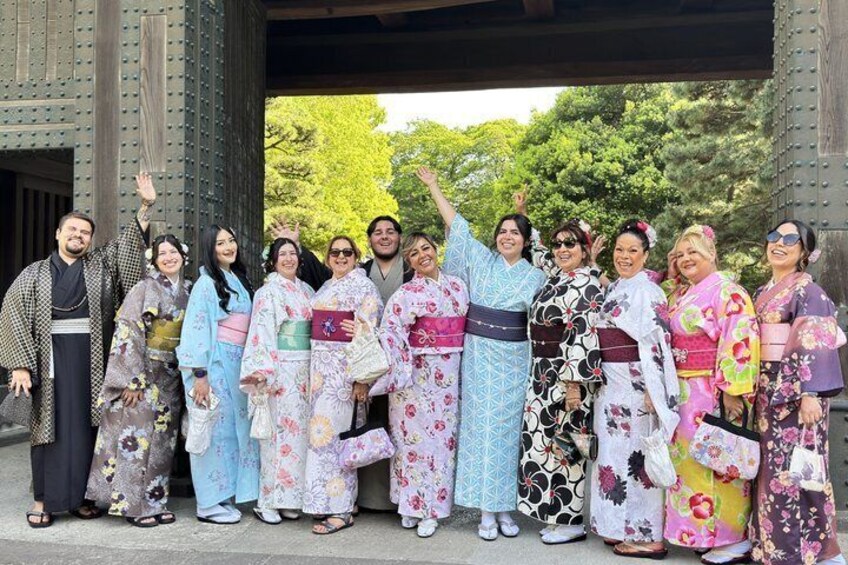 A group of people in traditional Japanese kimonos standing in front of a wooden structure. 1