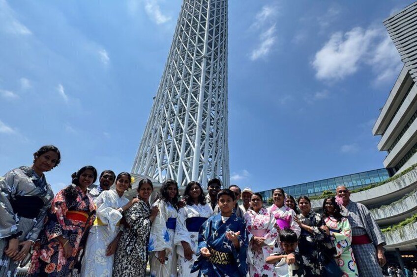 A group of people in front of a tall, modern tower with a lattice structure. 4