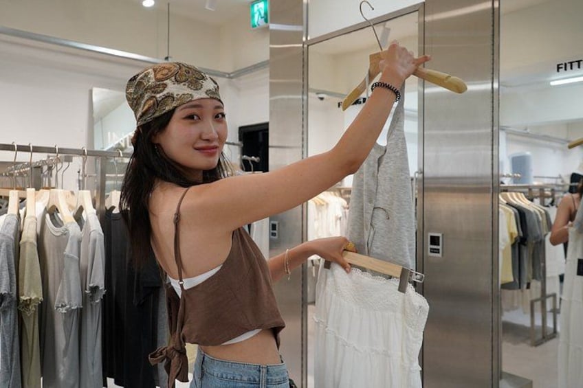 A person hanging clothes on a rack in a store. 1