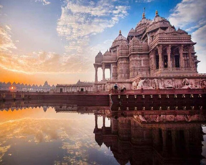 Een tempel met gedetailleerde architectuur, een reflectie in het water, en een zonsondergang. 1