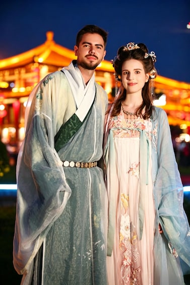 A couple in traditional attire with a pagoda in the background. 3