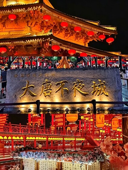 A traditional Chinese building with illuminated red lanterns and golden inscriptions. 2