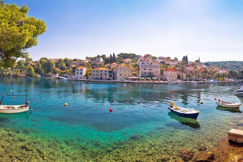 A clear lake with boats, a shoreline, and buildings in the background. 3