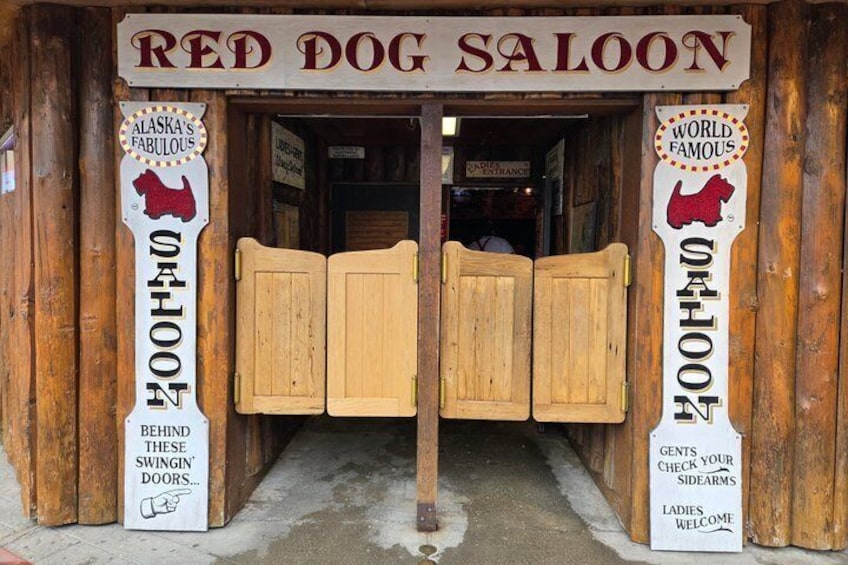 A wooden saloon entrance with signs stating 'Alaska's Fabulous Saloon' and 'World Famous Saloon.' 4