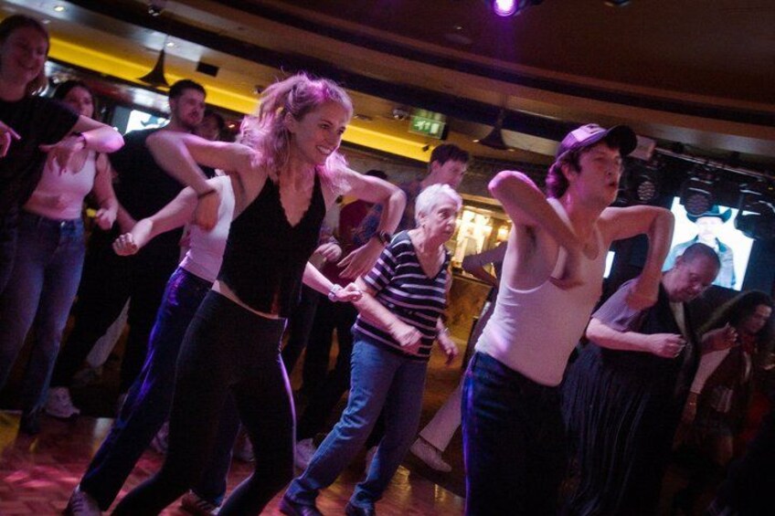 A group of people dancing in a dimly lit room. 4