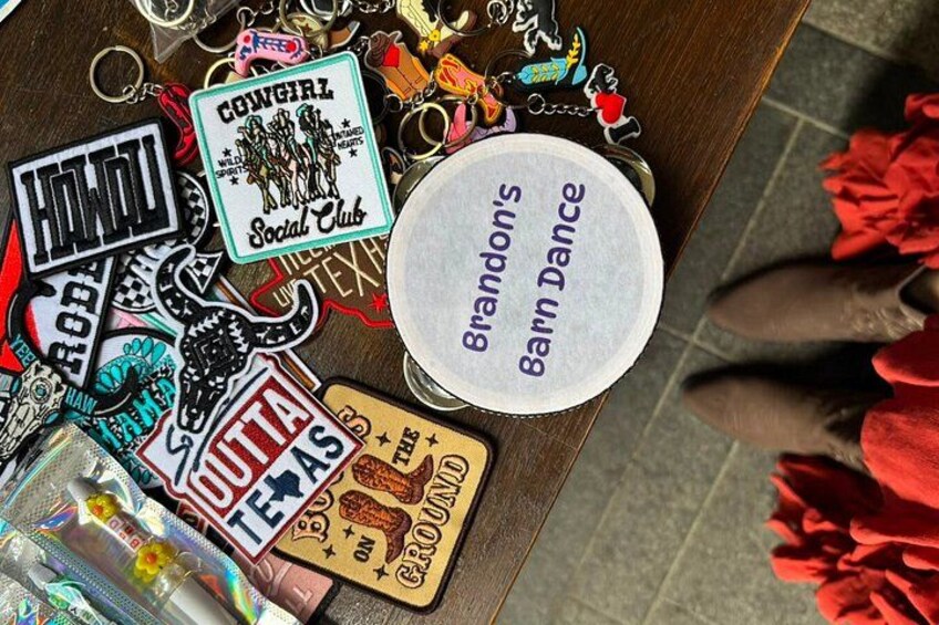 A collection of keychains and a round badge with text on a wooden surface. 4