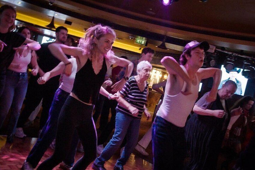 A group of people dancing in a dimly lit room. 4