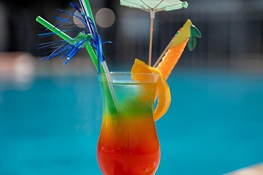 A cocktail with a colorful gradient, a straw, and a fruit garnish in a glass. 5