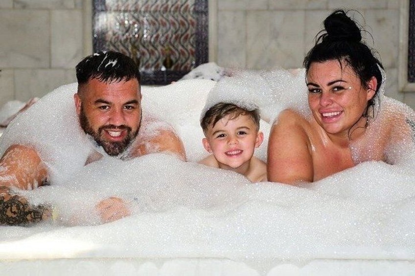 A family of three in a bubble bath. 5