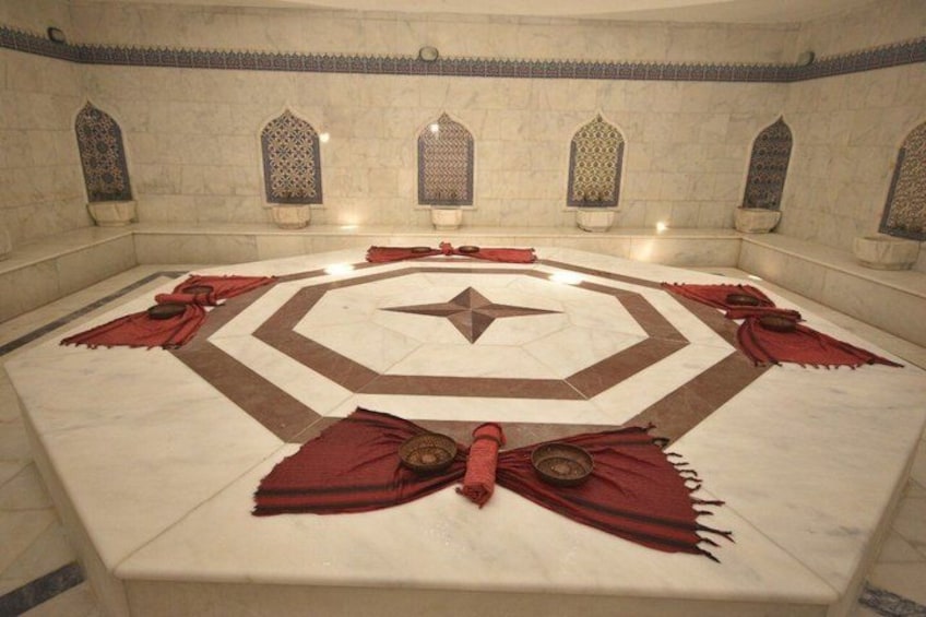 A circular room with a star pattern on the floor, red cloths, and decorative windows. 1
