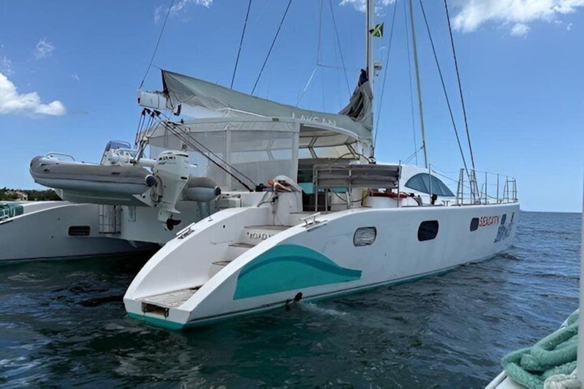 A white yacht with a green stripe, a covered deck, and a flag. 4