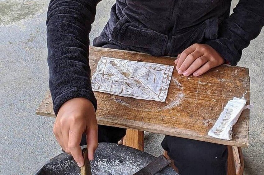 A person using a tool on a wooden board with a map. 2