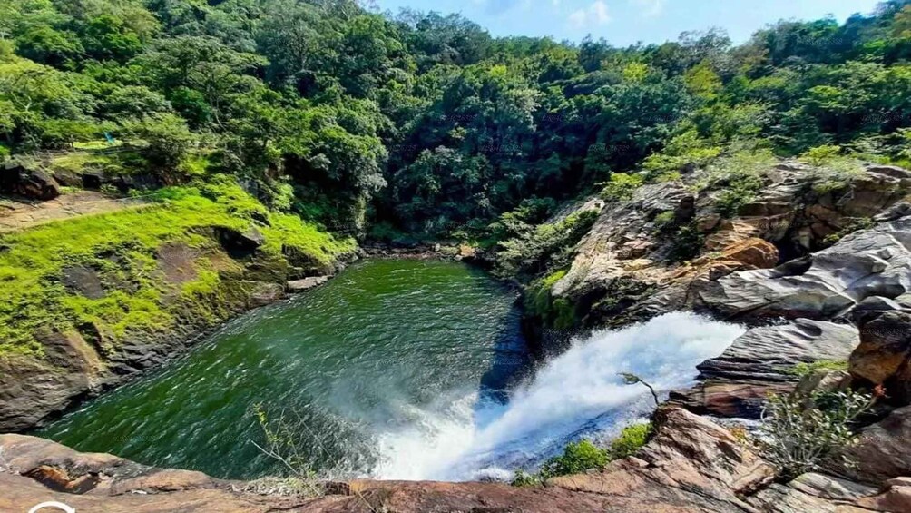 A waterfall in a forested valley with rocky terrain. 1