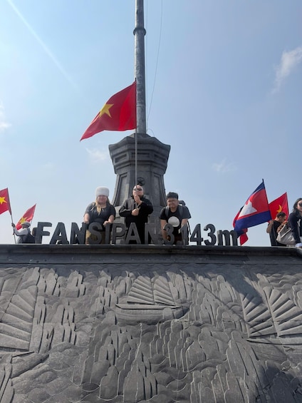 Monumentti, jossa on kaiverruksia ja lippuja, mukaan lukien lippu, jossa on keltainen tähti. 2