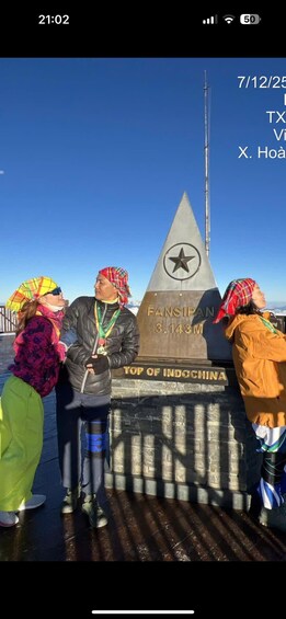 Ryhmä ihmisiä seisomassa «Indokiinan huipun» -muistomerkin luona, taustalla tähti-symboli. 5