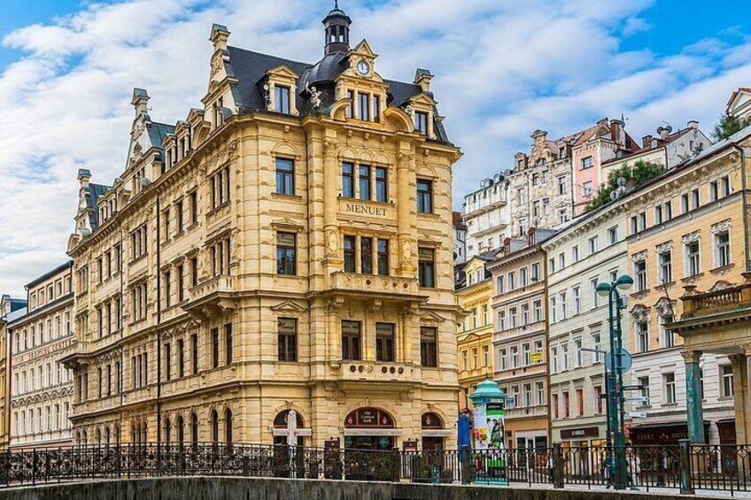 A historic building with ornate architecture, a prominent clock, and a street with other buildings. 3