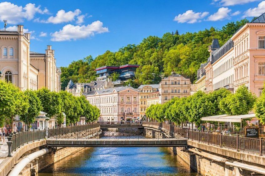 A river with a bridge, buildings, and trees. 1