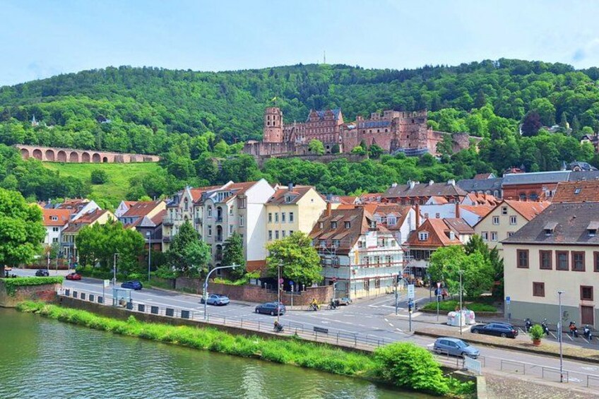 A river with a bridge, a town with historic buildings, and a castle on a hill. 3