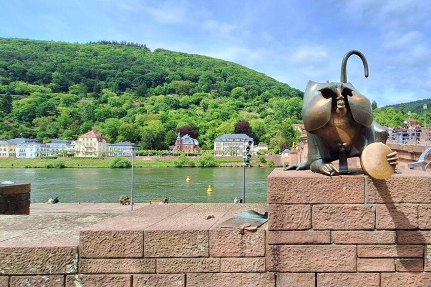A river with houses and a statue of an elephant on a brick platform. 5