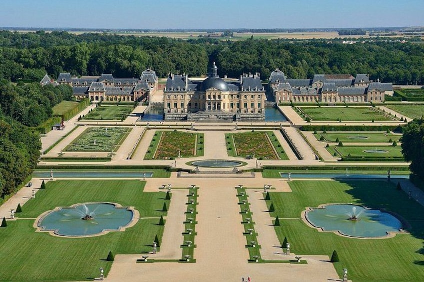 A grand palace with symmetrical gardens, fountains, and a central courtyard. 2