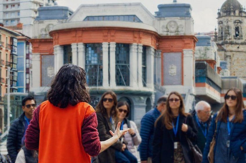 A group of people standing in front of a historic building with columns and a dome. 1