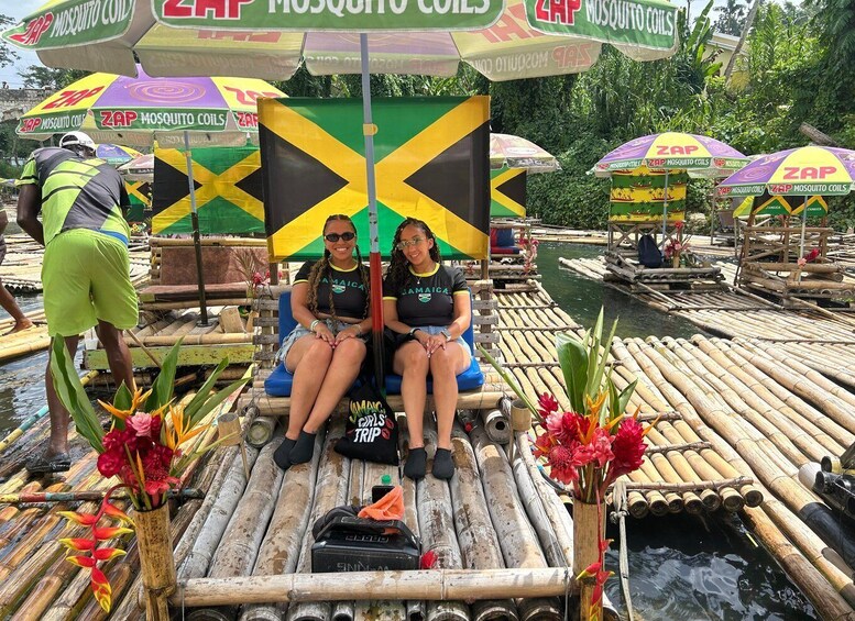 Two people on a floating platform with a flag, surrounded by water and greenery. 1