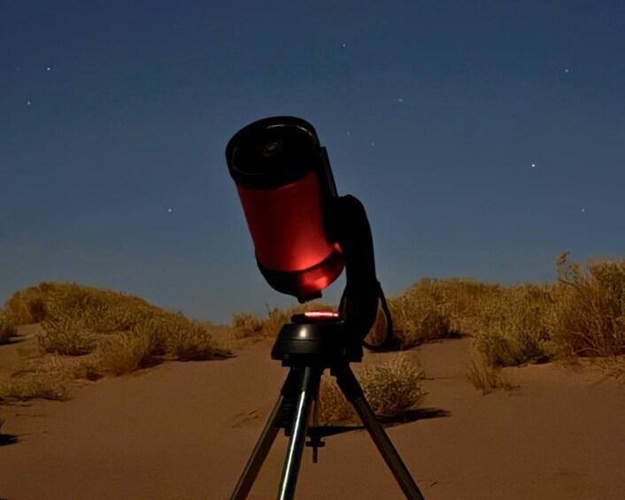 A telescope on a tripod in a desert landscape. 2