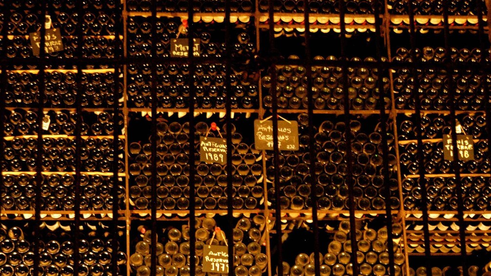 A wine cellar with rows of wine bottles, some labeled with years and types. 2