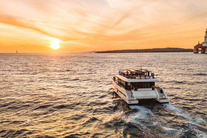 A white boat with passengers, a sunset, and a distant shoreline. 3