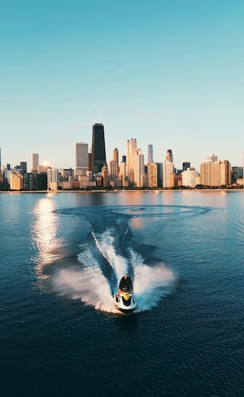 A jet ski speeding across a body of water with a city skyline in the background. 1
