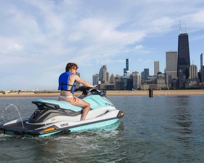 A person jet skiing on a body of water with a city skyline in the background. 2