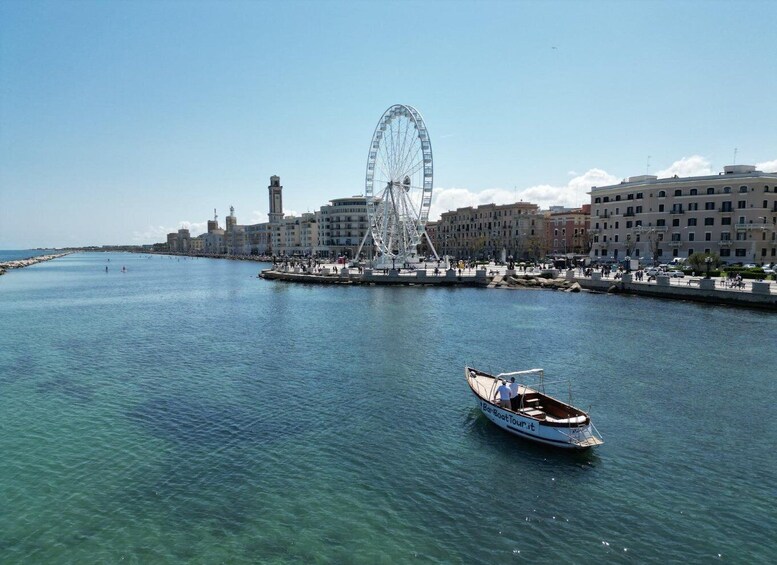 A Ferris wheel, a boat, and a waterfront cityscape. 1