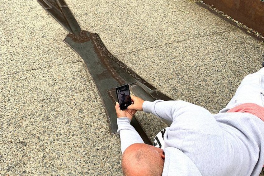 A person lying on the ground, holding a smartphone. 2